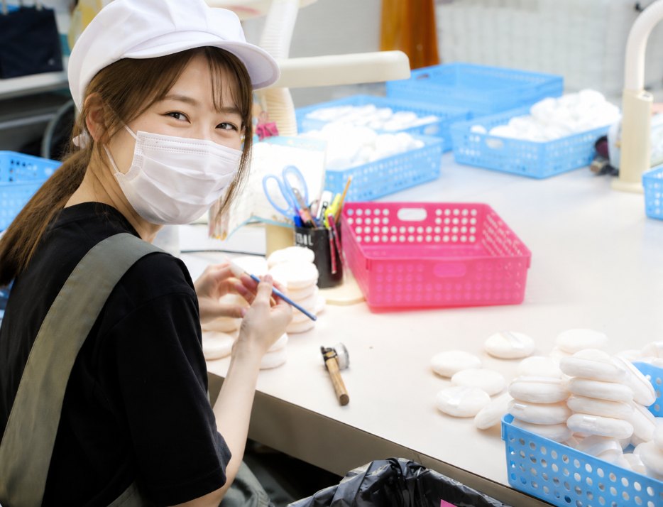 作業台でパフの検品をする女性スタッフ